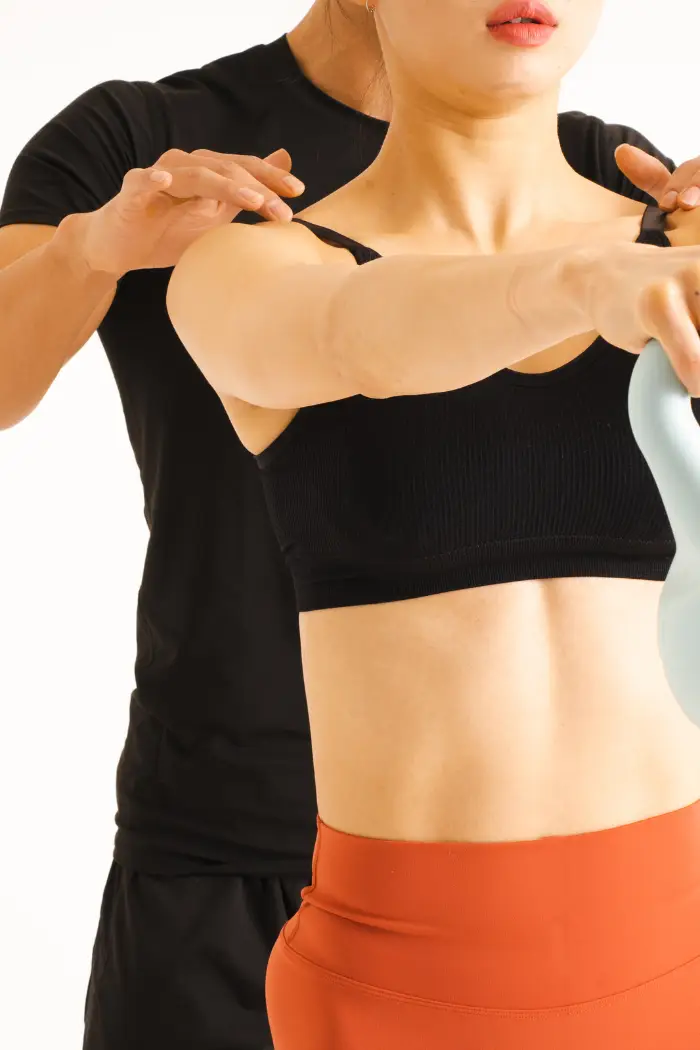 Un coach certifié qui corrige un élève dans sa posture.