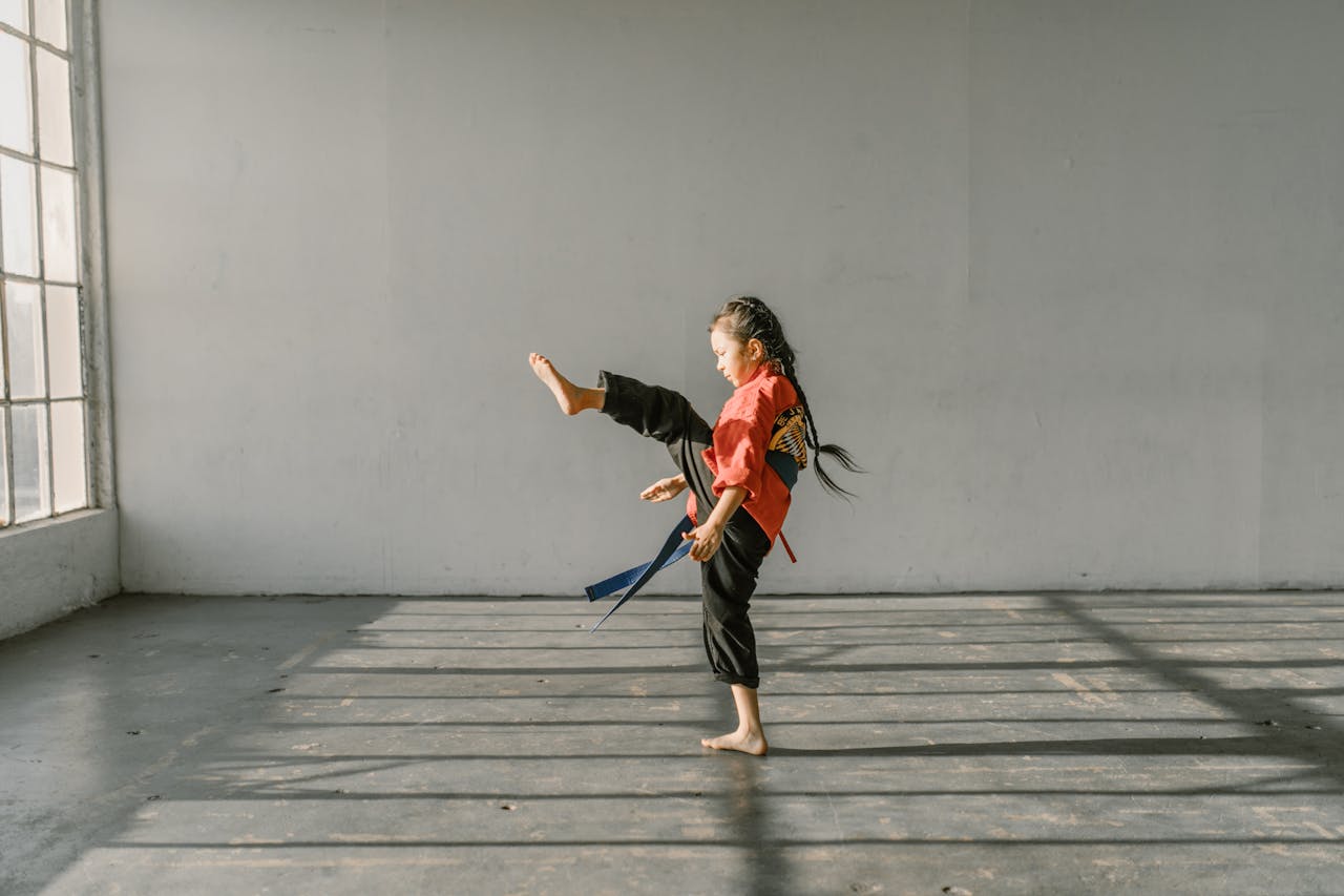 Une jeune fille pratiquant du kung fu et travaillant son coup de pied direct